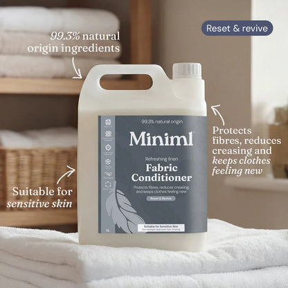 Fabric conditioner bottle with text highlighting features on a bed background