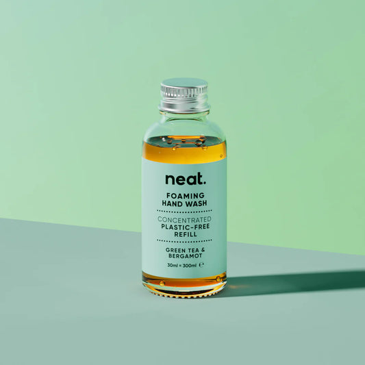Bottle of neat foaming hand wash on a green background