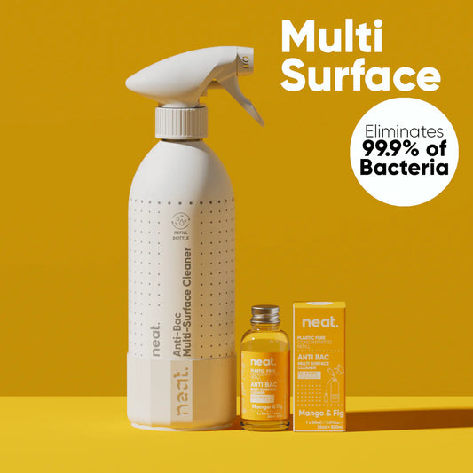White spray bottle with 'neat' branding on a yellow background, featuring text about eliminating bacteria.