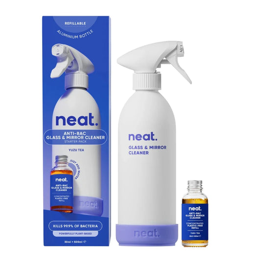 Neat glass and mirror cleaner set with bottle, box, and small container on a white background