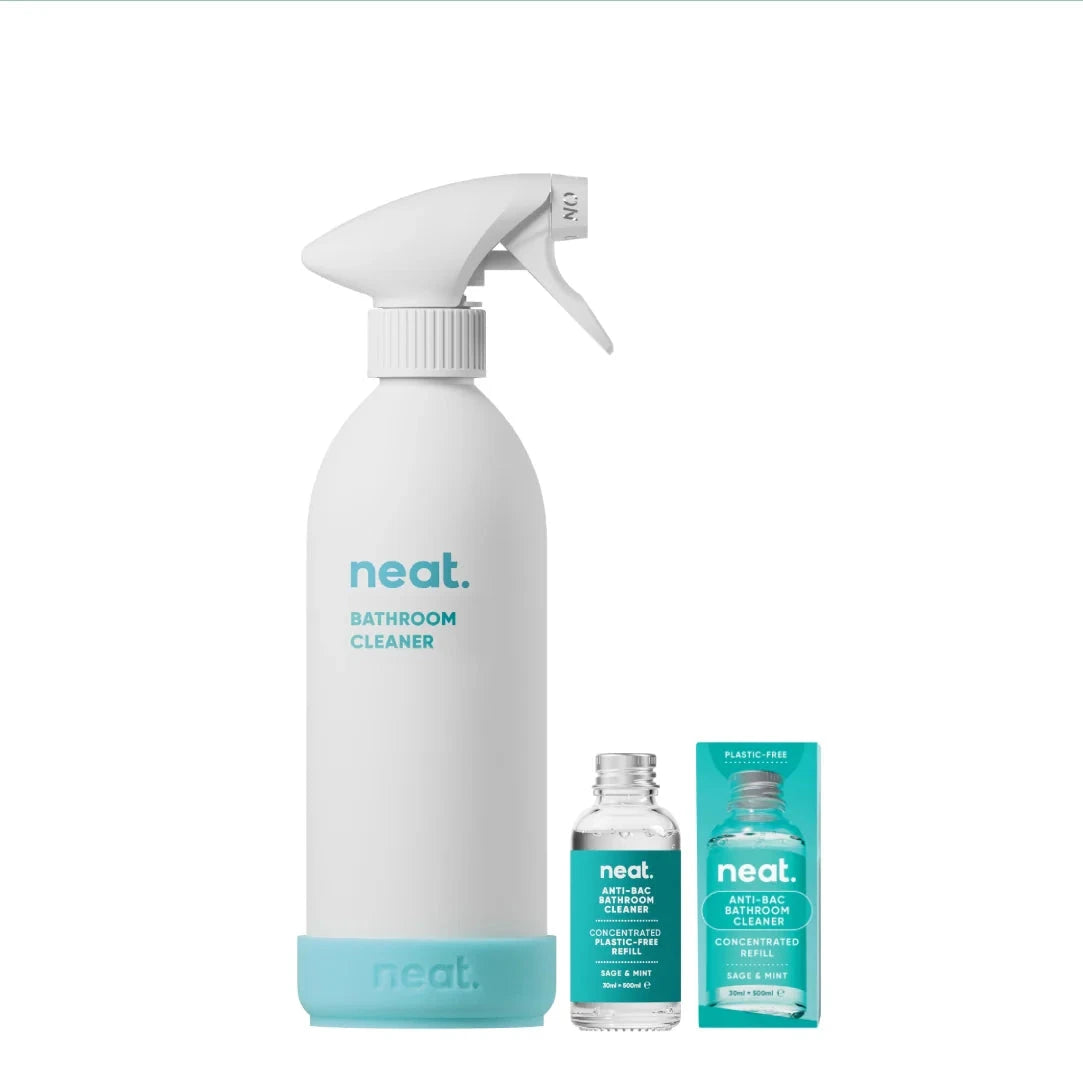 White spray bottle labeled 'neat' with smaller bottles and packaging on a white background